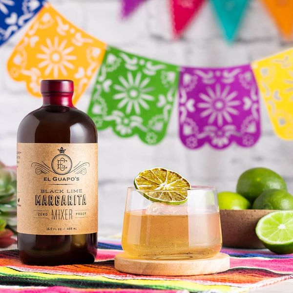 Bottle of El Guapo Black Lime Margarita Mixer with a garnished drink.