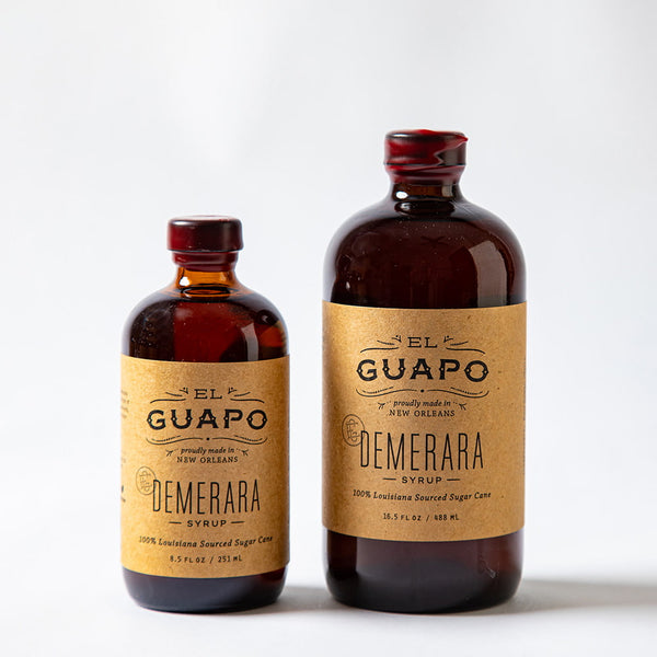 Size comparison of two bottles of El Guapo Demerara syrup on a white background
