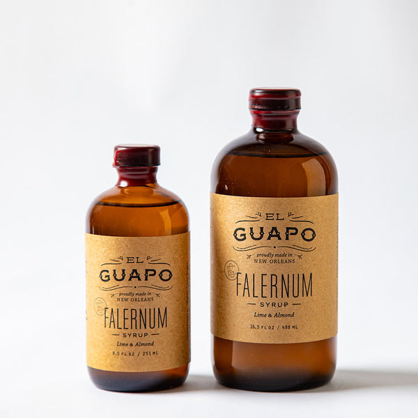 Size comparison of two bottles of El Guapo Falernum syrup with labels on a white background