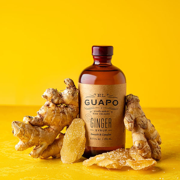 8.5 oz small bottle of El Guapo Ginger Syrup with ginger roots on a yellow background