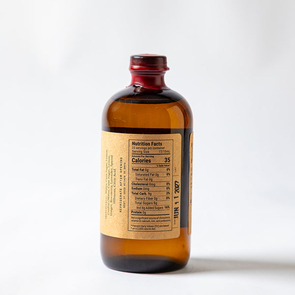 Side profile of large 16.5 oz El Guapo Hibiscus Syrup bottle with nutritional panel and ingredient list showing on a white background