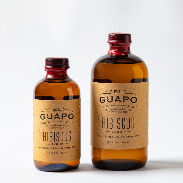 Size comparison of two bottles of El Guapo Hibiscus Syrup on a white background