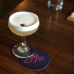 Soji Modern Asian foam topped cocktail garnished with a rosebud