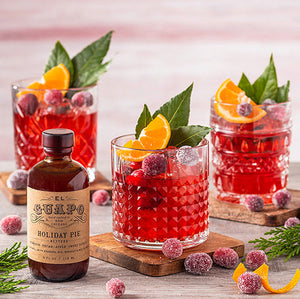 Candied Cranberry Old Fashioned cocktails next to El Guapo Holiday Pie Bitters