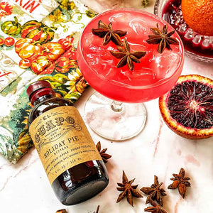 Blood Orange Holiday Pie Daiquiri garnished with star anise next to El Guapo Bitters