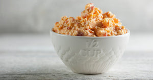Crawfish Boil Pimento Cheese spread inside a white ceramic measuring cup bowl