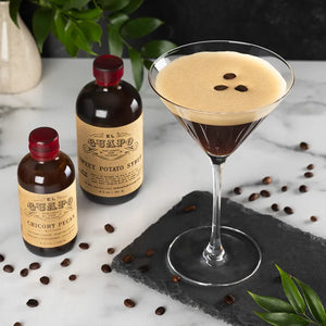 Espresso martini cocktail next to El Guapo Sweet Potato Syrup and Chicory Pecan Bitters