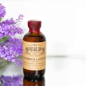 El Guapo Cucumber Lavender Bitters bottle with purple lavender flowers in the background