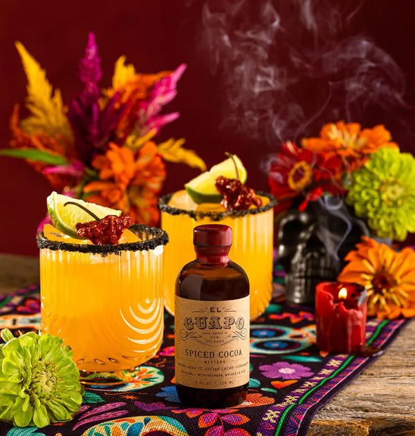 Day of the Dead Muertos Margaritas next to a bottle of El Guapo Spiced Cocoa Bitters