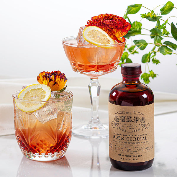 Springtime sloe gin spritzers with lemon slices next to a bottle of El Guapo Rose Cordial