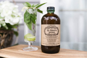 Spicy mint mojito cocktail next to a bottle of El Guapo Lime Cordial