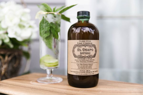 Spicy mint mojito cocktail next to a bottle of El Guapo Lime Cordial