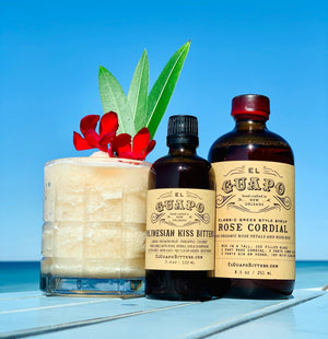 Fancy Frozen Floral Lemonade next to El Guapo Polynesian Kiss Bitters and Rose Cordial