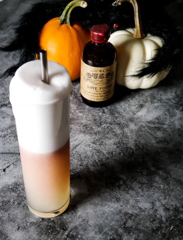 Haunted Estate Fizz cocktail with thick foam, pumpkins, and El Guapo Love Potion Bitters