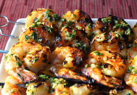 Broiled lemon garlic shrimp skewers garnished with fresh herbs
