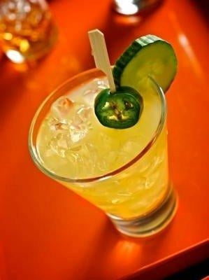 Spicy jalapeño cucumber margarita cocktail on an orange tray