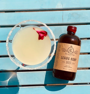 Meyer Lemon Martini with a sugar rim next to a bottle of El Guapo Lemon Drop Mixer