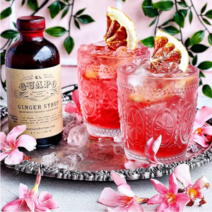 Two Sour Cherry and Ginger Margaritas on a silver tray next to El Guapo Ginger Syrup