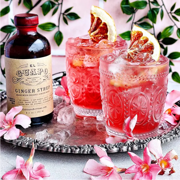 Two Sour Cherry and Ginger Margaritas on a silver tray next to El Guapo Ginger Syrup