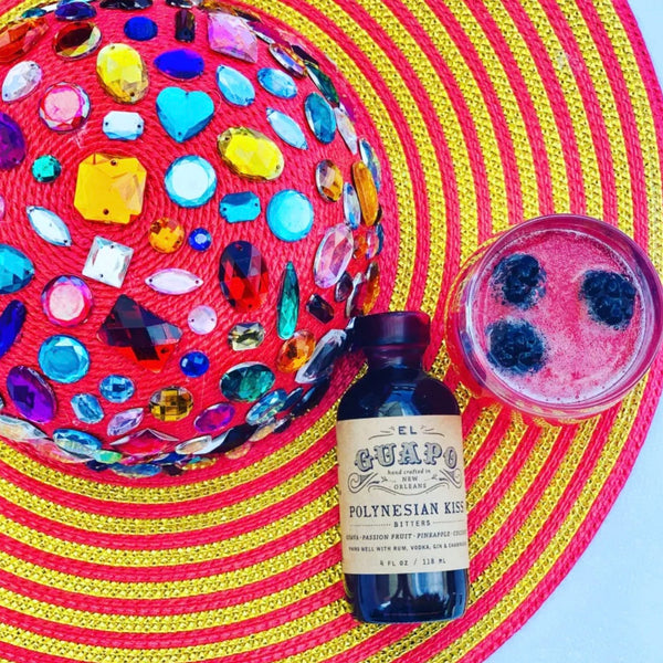 The Poolside Polynesian cocktail with blackberries next to El Guapo Polynesian Kiss Bitters