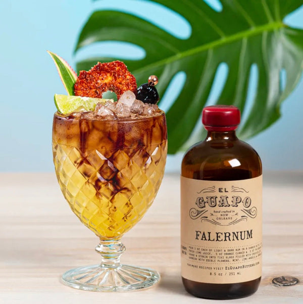 Tiki Tolteca cocktail with lime and crushed ice next to El Guapo Falernum