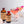 An 8.5 oz bottle of El Guapo Rose Cordial and bottle of El Guapo Love Potion Bitters next to two pink cocktails garnished with pink flowers on a light background.