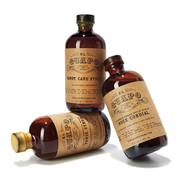 Three bottles of El Guapo syrups on a white background