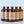 Five full-size bottles of assorted El Guapo mixers on a light blue background