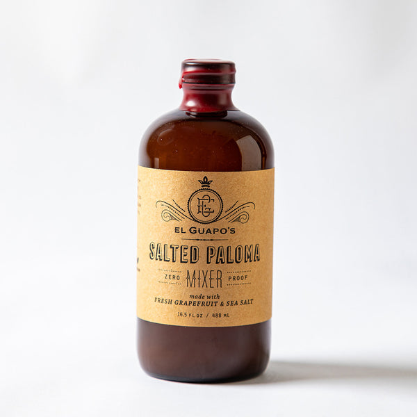 Glass full size bottle of El Guapo Salted Paloma Mixer on a white background