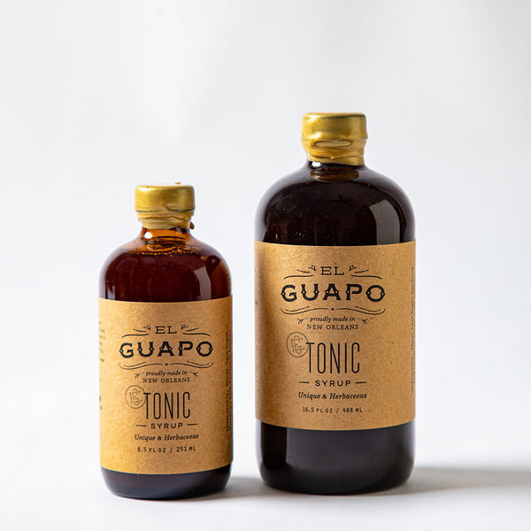 Size comparison of two bottles of El Guapo Tonic Syrup on a white background