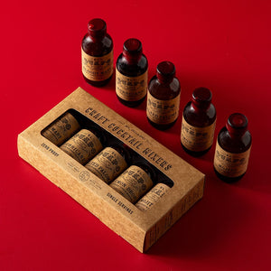 Set of single serving El Guapo Craft Cocktail Mixers with a paperboard packaging box on a red background