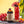 Bottle of El Guapo Hurricane Mixer with a Hurricane cocktail garnished with flowers, cherries and oranges on a colorful tablecloth.
