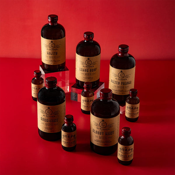 Collection of full size and single serving El Guapo Mixer bottles on a red background