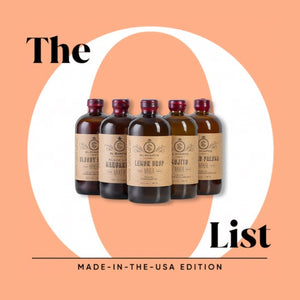 A 6-pack of El Guapo craft cocktail mixers, one of each flavor styled against a peach background with the text 'The O List' and 'MADE-IN-THE-USA EDITION'.